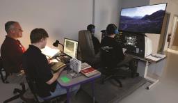 Students work on a simulator with an instructor watching from a different screen 