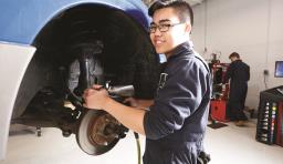 a student works on a car