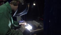 A student uses a welding machine
