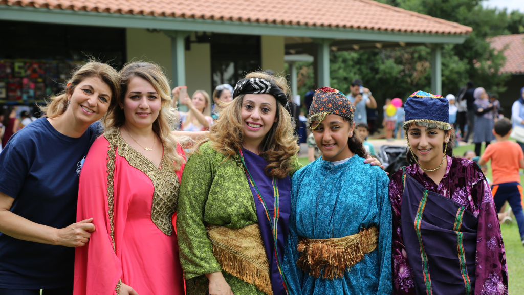 Students in their cultural dress smile at the camera