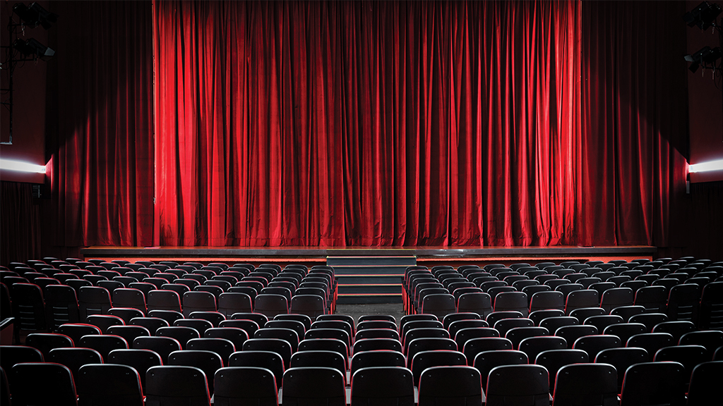 an empty theatre with deep red curtains