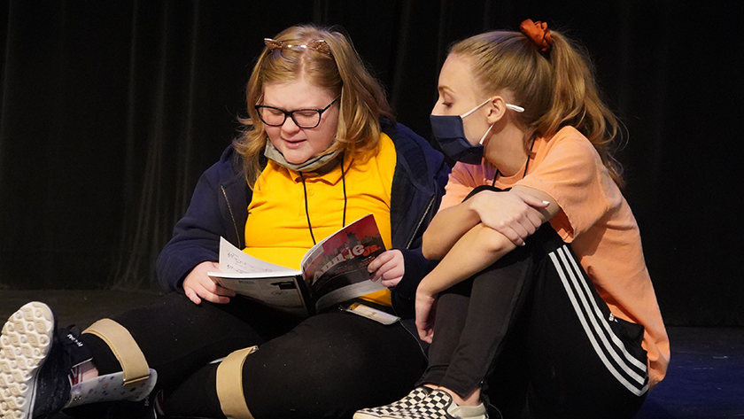 Students review the script for a production of “Annie, Jr.” 