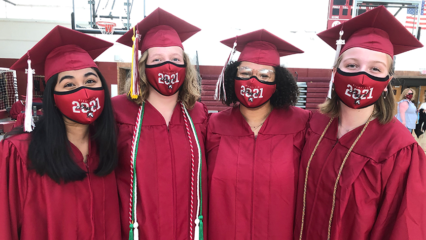 Four girls pose in caps and gowns
